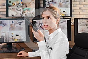 Female security guard with portable transmitter at workplace.