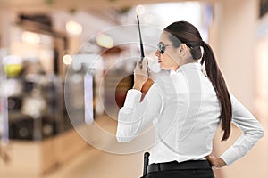 Female security guard using portable radio transmitter in mall