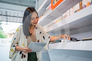 female seller holding the digital tablet while arranging the vape mods