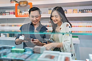 female seller holding the digital tablet while observing the vape mods