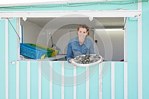 female seller selling fresh fish and chilled seafood at market