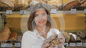 Female seller takes black bread from the rack