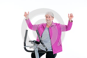 Female senior with arms up train with fitness machine