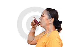 Female senior patient uses brown asthma inhaler for relief asthma.