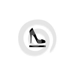 Female shoe with high heel on pedestal. Elegant black slipper with spike heel on while background