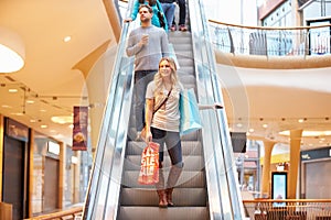 Female Shopper On Escalator In Shopping Mall