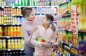 Female shopper with teenage daughter searching for beverages