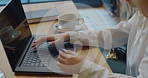 Female shopping online with credit card, using laptop pc, sitting at the table in cafe.