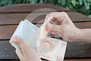 Female Showing Counting Turkish Money Lira on Outdoor Table Summer Canakkale 2017 Turkey photo