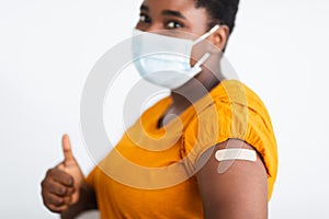 Female Showing Vaccinated Arm And Thumbs-Up Approving Covid-19 Vaccine, Studio