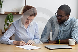 Female signing job contract sitting together with company owner photo