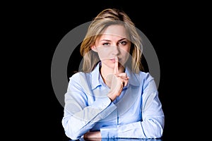 Female in silent gesture with finger on her lips photo