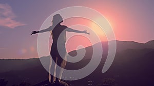 Female silhouette at beautiful sunset, mountain background