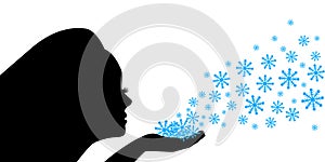 Female silhouette blows snowflakes from the palm