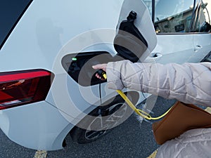 Female silhouette charging a electric car, photo from below