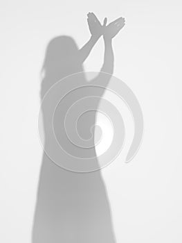 Female silhouette with hands creating a bird shape