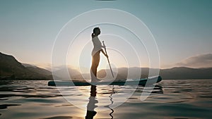 Female silhouette on water, Sup board, paddle boarding in slow motion