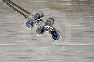 Female silver jewelry with blue gems, diamonds on a beige background in the upper left corner