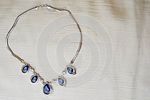 Female silver jewelry with blue gemstones, diamonds