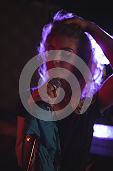 Female singer with hand in hair performing in nightclub