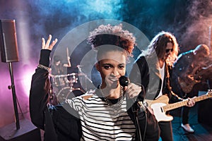Female singer with microphone and rock and roll band performing hard rock music