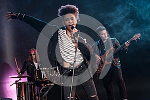 Female singer with microphone and rock and roll band performing hard rock music