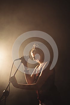 Female singer performing in illuminated nightclub