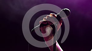 Female singer on the stage holding a microphone.CU