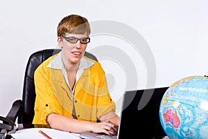 Female sitting behind a desk in bright, yellow jacket