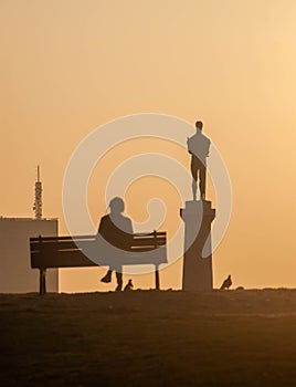 Female sitting on the bench in the background of the victor monument