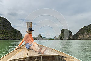 a female sitting on a boat in phang nga bay