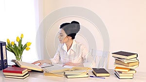 Female sitting at her workplace and laughing while reading holding book