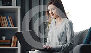 Female sitting sofa with laptop