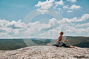 Female sitting on split. Fit woman training outdoors. Yoga time, Sport and Healthy lifestyle concept. Beautiful view