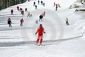 Female skier skiing down a piste photo