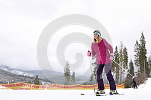 Female skier on slope at resort, space for text. Winter