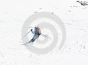 Female skier tackling a steep slope.