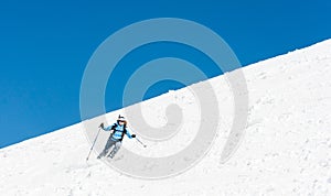 Female skier tackling a steep slope.