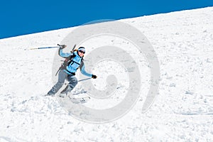 Female skier tackling a steep slope.