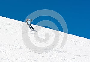 Female skier tackling a steep slope.