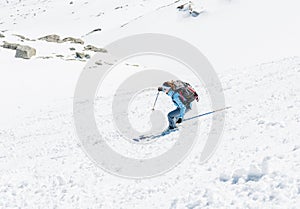 Female skier tackling a steep slope.