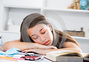 Female is sleeping after studying