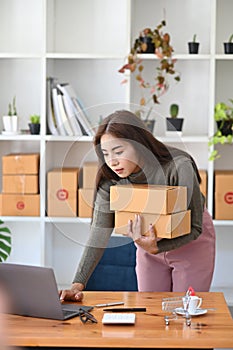 Female small business entrepreneur preparing deliveries for clients at her home.