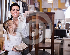 Female with small daughter are choosing curbstone