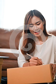 Female SME online business shop owner preparing a shipping boxes in the living room