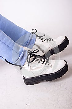 Female sneakers. White female shoes on feet. Sneakers closeup