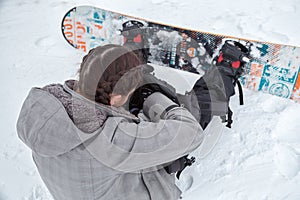 Female snowboarder is searching stuff inside the backpack