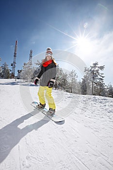 Female snowboarder snowboarding in mountain