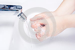 Female Soaped Hands Over A Basin Ready To Wash Under The Running Water