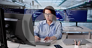 Female Software Engineer Typing Code On Computer At Office Desk